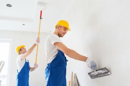 business-building-teamwork-people-concept-group-builders-hardhats-with-plastering-tools-indoors.jpg